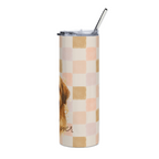 A tall insulated tumbler with a clear lid and metal straw, featuring a pastel checkerboard pattern in peach, beige, and cream, with part of a brown dog illustration and the word 'ever' visible on the lower left.